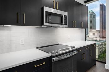 A kitchen with black cabinets and white countertops